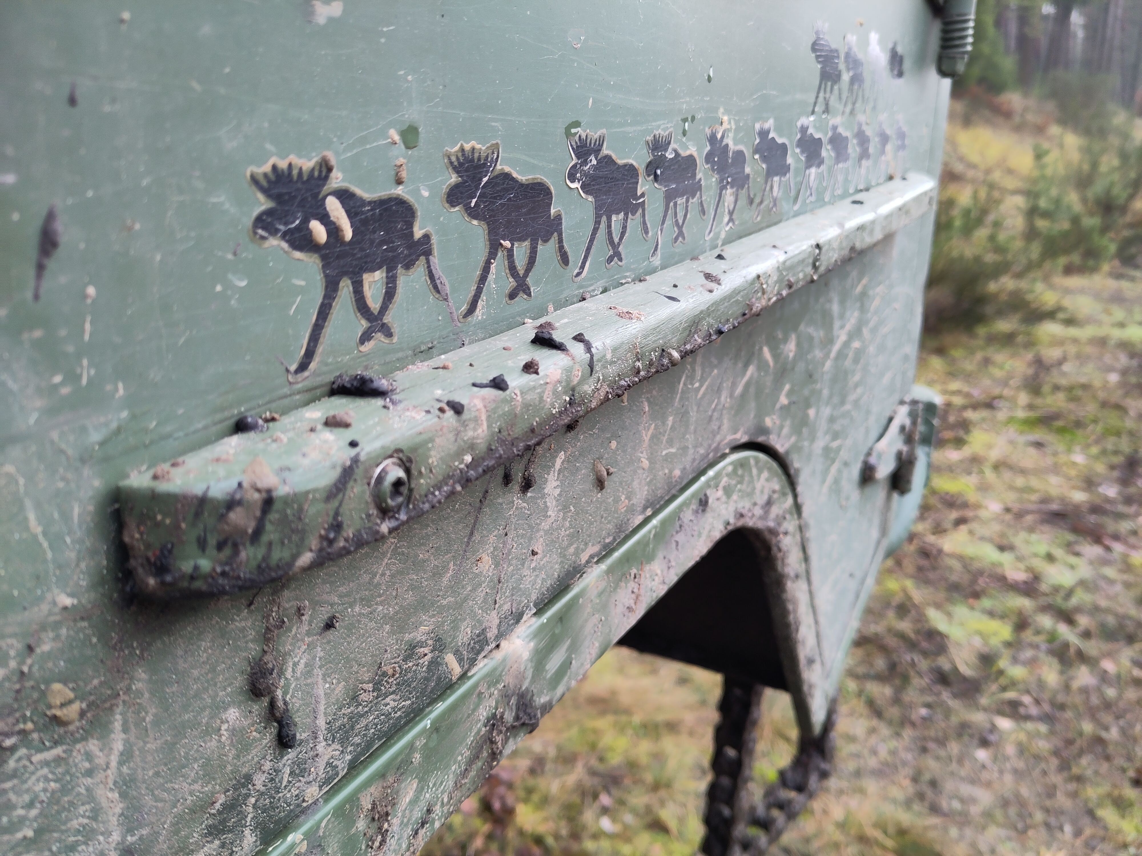 Foto in Nahaufnahme von der Beifahrertür, die mit Schlamm in verschiedenen Brauntönen bespritzt ist.
