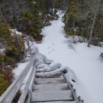 Foto: Treppe, die halb von Schnee bedeckt ist.